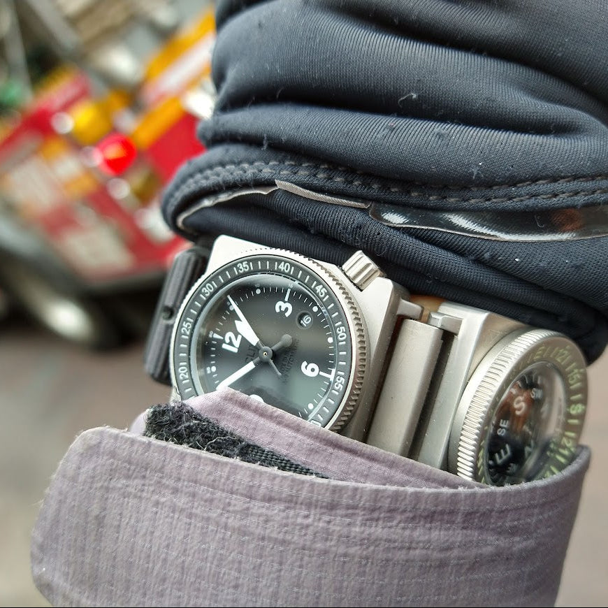 SCOUT worn outdoors under layered sleeves, showing the compact titanium platform in use.