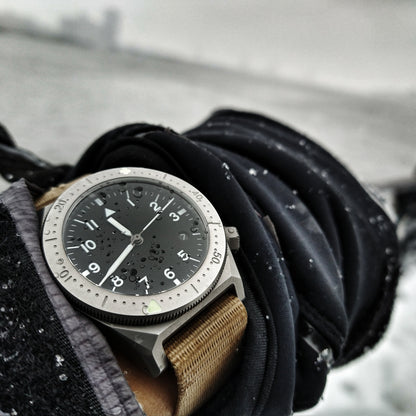 Watch on a gloved hand with a snowy background