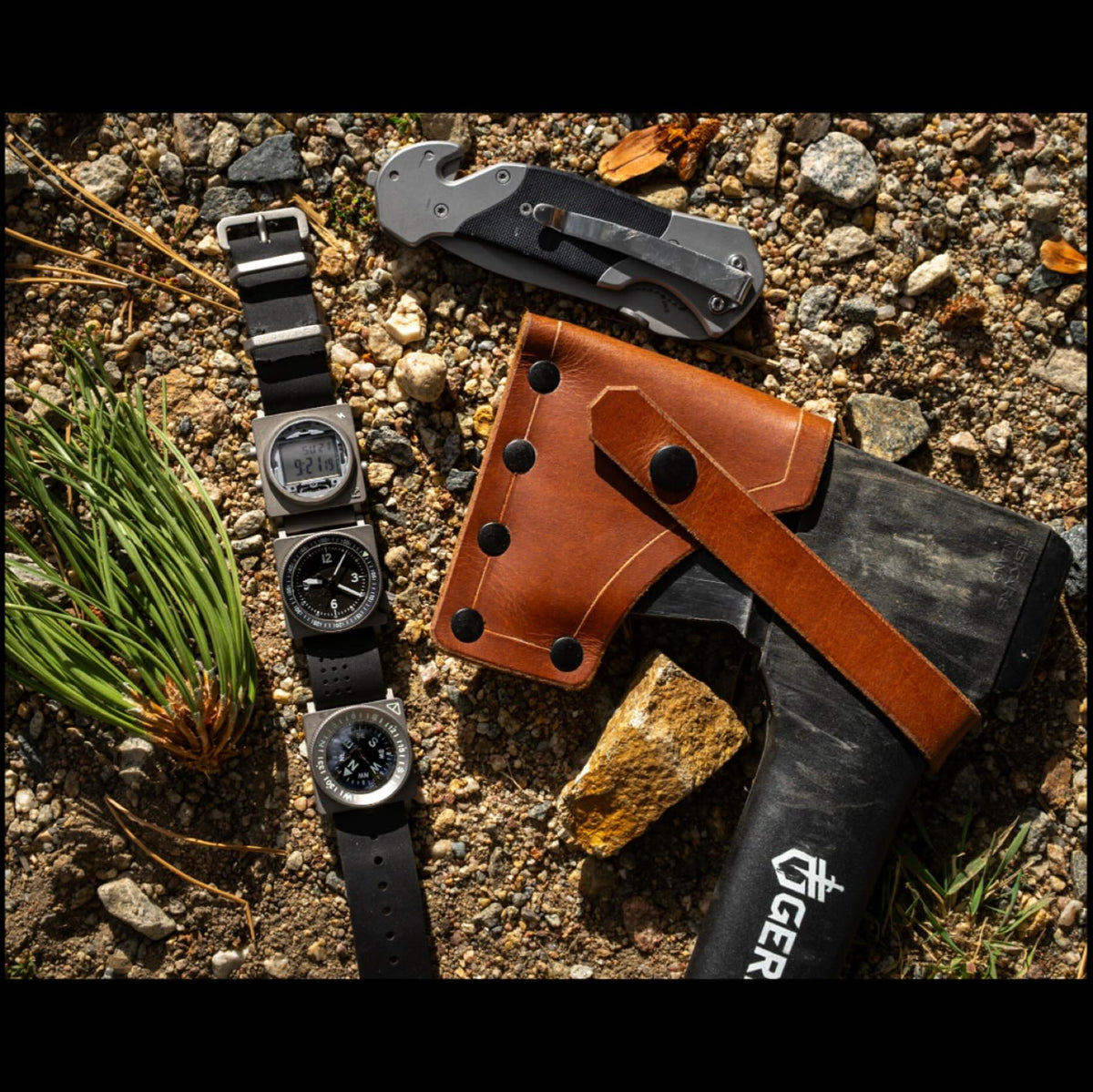 SCOUT A-9, digital, and compass instruments on a strap beside outdoor tools on gravel.
